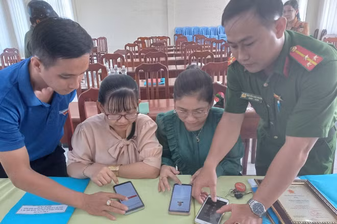 Công an xã Tân Hộ Cơ phối hợp Đoàn Thanh niên trên địa bàn xã hướng dẫn người dân cài đặt ứng dụng VNeiD trên điện thoại thông minh.