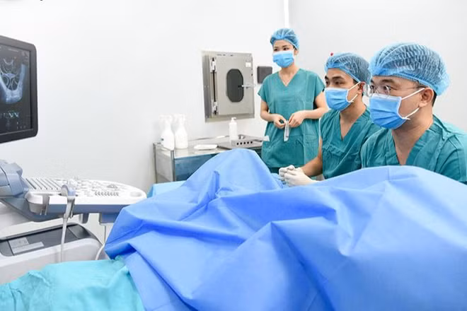 Phó Giáo sư, Tiến sĩ Lê Hoàng đang chọc hút noãn cho người bệnh.
