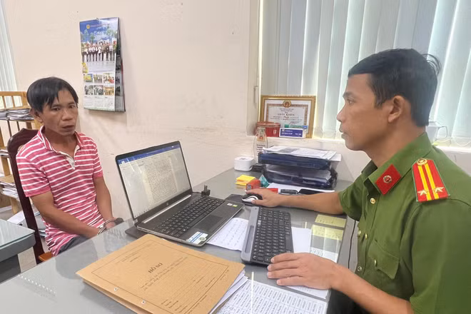 Cán bộ điều tra lấy lời khai nghi can Lê Huy Dũng.