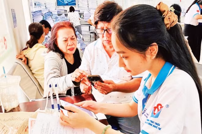 Tình nguyện viên Trung tâm Phát triển khoa học và công nghệ trẻ (Thành đoàn TP Hồ Chí Minh) hỗ trợ người dân làm các thủ tục hành chính.