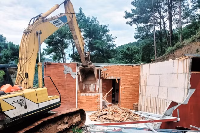 Lực lượng chức năng phá dỡ công trình vi phạm đất rừng, trật tự xây dựng.