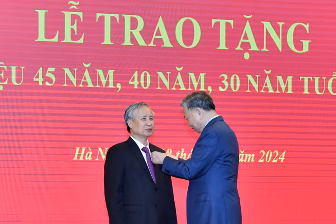 Tổng Bí thư Tô Lâm gắn Huy hiệu 45 năm tuổi đảng tặng đồng chí Trần Quốc Vượng. (Ảnh: ĐĂNG KHOA)