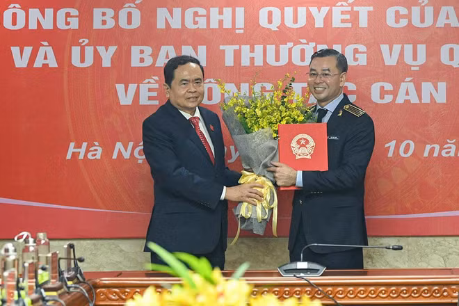 Phó Chủ tịch Thường trực Quốc hội Trần Thanh Mẫn trao Nghị quyết và tặng hoa cho Tổng Kiểm toán Ngô Văn Tuấn. (Ảnh: DUY LINH)