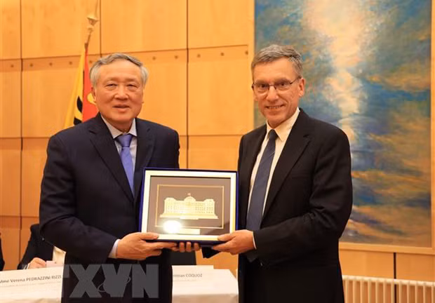 Chánh án Tòa án Nhân dân Tối cao Nguyễn Hòa Bình (trái) tặng quà lưu niệm cho ông Christian Coquoz, Chánh án Tòa án bang Geneva. (Ảnh: TTXVN)