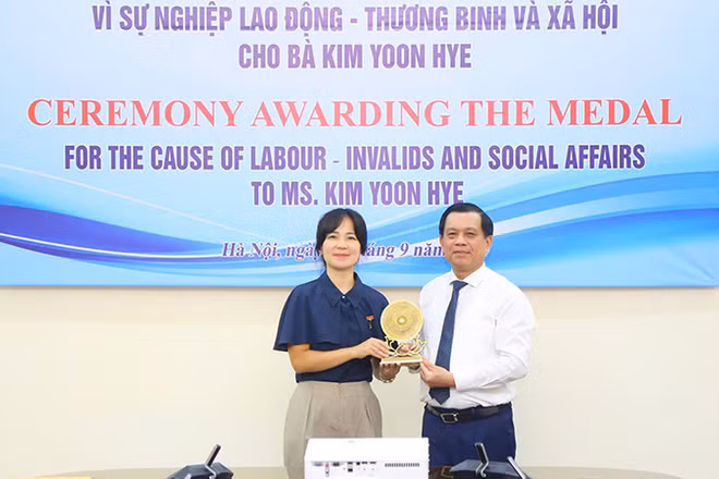 Trao tặng Kỷ niệm chương “Vì sự nghiệp lao động-thương binh và xã hội” cho Tùy viên lao động và việc làm Đại sứ quán Hàn Quốc tại Việt Nam Kim Yoon Hye. (Ảnh: Molisa)