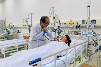 Phó Giáo sư, Tiến sĩ, bác sĩ Phạm Văn Quang, Trưởng khoa Hồi sức tích cực-Chống độc, Bệnh viện Nhi đồng 1 khám bệnh nhi nữ 12 tuổi từ Trà Vinh. (Ảnh: CHI MAI)