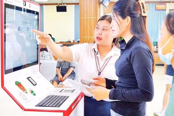 Cán bộ hướng dẫn người dân thực hiện thủ tục hành chính tại Trạm dịch vụ công số, Trung tâm Phục vụ hành chính công tỉnh Ninh Bình. 