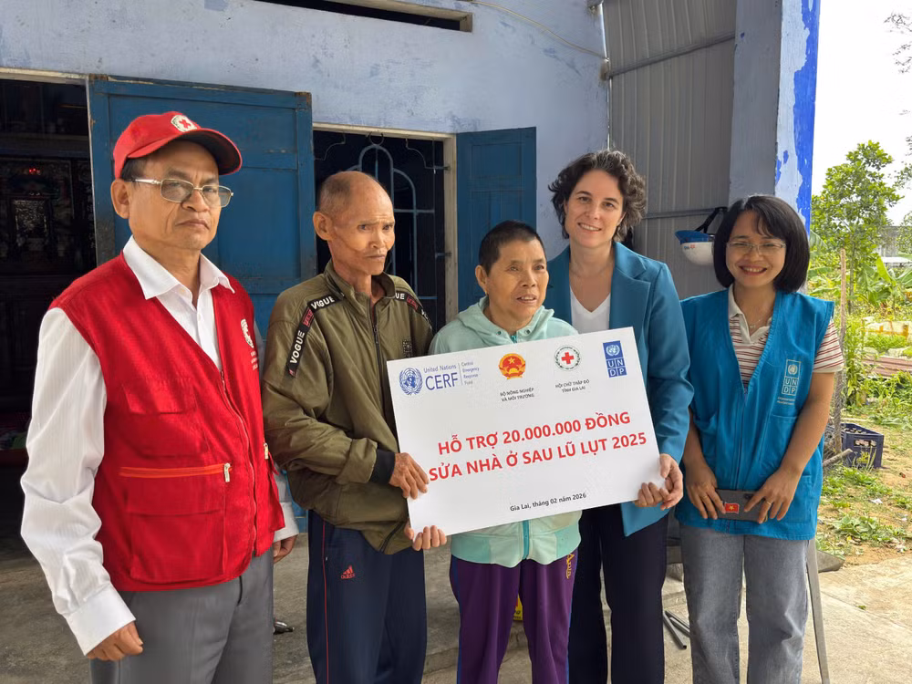 Đại diện Chương trình Phát triển Liên hợp quốc (UNDP) trao tiền hỗ trợ cho gia đình bị ảnh hưởng bởi bão lũ.