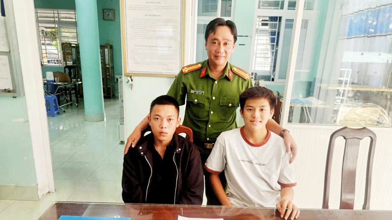 Cán bộ Công an phường Rạch Giá chụp ảnh cùng em Huỳnh Minh Khánh (bên phải) và người chuyển tiền nhầm.
