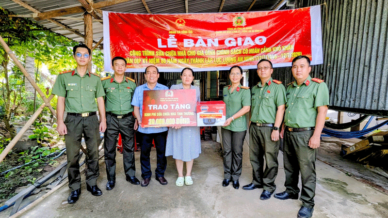 Thừa ủy quyền của Đảng ủy, Ban Giám đốc Công an tỉnh An Giang, Thượng tá Nguyễn Thị Hồng Loan, Phó trưởng phòng An ninh kinh tế Công an tỉnh và lãnh đạo xã Vĩnh Gia trao tặng kinh phí sửa chữa nhà và quà cho chị Bùi Kiều Diễm (người đứng thứ 4 từ phải qua). (Ảnh: NGHIÊM TÚC)