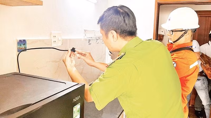 Lực lượng công an và công nhân ngành điện Thành phố Hồ Chí Minh phối hợp kiểm tra an toàn hệ thống điện tại một khu nhà trọ ở phường Phú Thọ Hòa (Ảnh QUANG QUÝ)