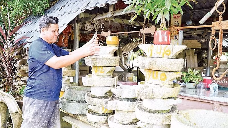 Ông Lê Văn Dũng thao tác quay cối xay bột quen thuộc, tái hiện lại nét sinh hoạt văn hóa ẩm thực dân gian xưa.