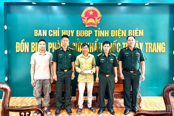 Đại diện lãnh đạo Đồn Biên phòng Cửa khẩu quốc tế Tây Trang chứng kiến Thiếu tá Nông Văn Thiết (người đầu tiên bên phải) trả lại tiền cho người đánh rơi. (Ảnh: LÊ LAN)