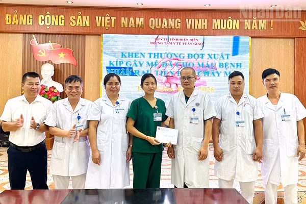 Lãnh đạo Trung tâm Y tế Tuần Giáo trao thưởng, động viên thành viên kíp trực đã phẫu thuật, cấp cứu và hiến máu cứu bệnh nhân qua cơn nguy kịch. (Ảnh: LÊ LAN)