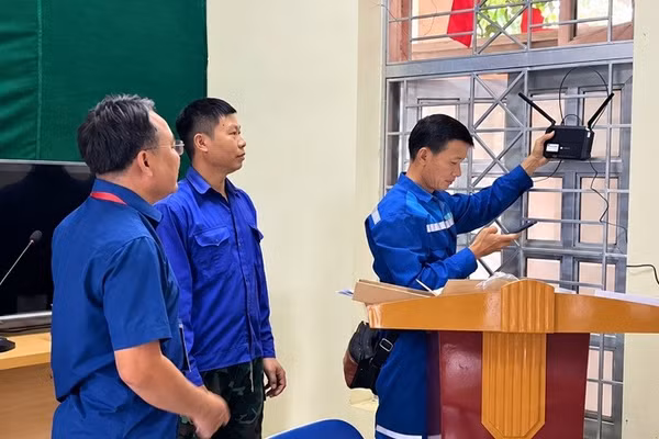 Công nhân đơn vị viễn thông lắp đặt bộ phát wi-fi tại Nhà Văn hóa bản Mường, xã Mường Mùn, tỉnh Điện Biên. (Ảnh: MƯỜNG MÙN)