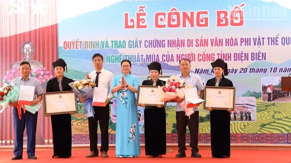 Đồng chí Nguyễn Thị Thanh Chuyên, Phó Giám đốc Sở Văn hóa, Thể thao và Du lịch Điện Biên trao Bằng Công nhận Di sản văn hóa phi vật thể quốc gia cho Nghệ thuật múa của người Cống cho nhân dân dân tộc Cống xã Nậm Kè. (Ảnh: LÊ LAN)