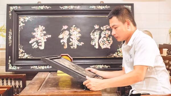 Nghệ nhân trẻ Phan Tấn Đạt bên một sản phẩm khảm ốc.