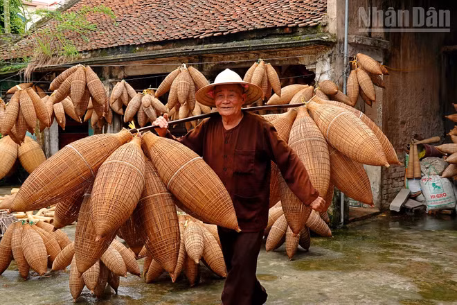 Nghệ nhân Lương Sơn Bạc gánh trên vai những chiếc đó bằng tre. Ảnh: LINH VŨ
