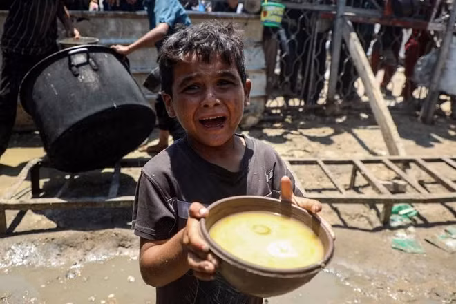 Một em bé Palestine nhận thức ăn miễn phí từ bếp ăn từ thiện ở thành phố Gaza, ngày 24/7/2025. (Ảnh: Tân Hoa Xã)