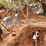 Các lực lượng thực hiện khai quật, lấy mẫu hài cốt liệt sĩ tại Nghĩa trang liệt sĩ Nhổn, phường Tây Tựu, Hà Nội. (Ảnh: MAI HOA)