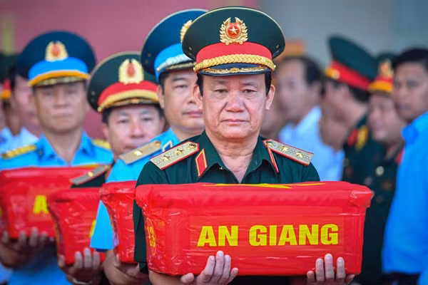 Trung tướng Hồ Văn Thái, Chính ủy Quân khu 9 trực tiếp nâng thùng mẫu hài cốt liệt sĩ trong nghi thức vận chuyển, bàn giao phục vụ giám định ADN. (Ảnh: PHƯƠNG VŨ)