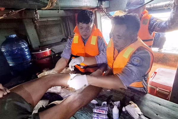Cán bộ, chiến sĩ Cảnh sát biển tiến hành băng bó vết thương và cầm máu cho ngư dân gặp nạn. (Ảnh: Bộ Tư lệnh Vùng Cảnh sát biển 4)
