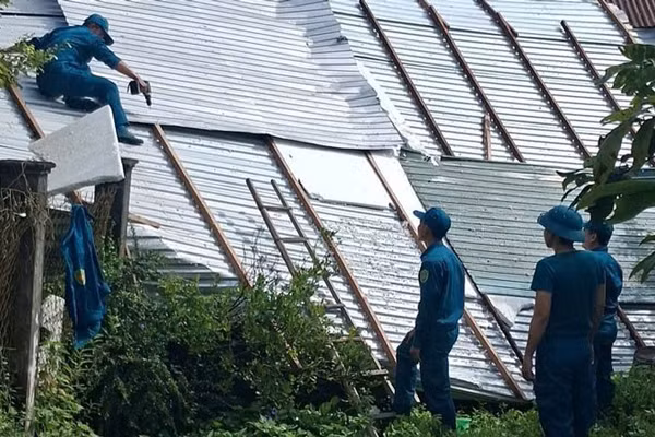 Lực lượng quân đội cùng công an và lực lượng tại chỗ hỗ trợ người dân khắc phục hậu quả của mưa lớn kèm dông lốc gây thiệt hại. (Ảnh: PHƯƠNG VŨ)