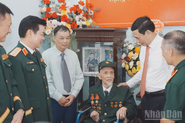 Đoàn công tác lãnh đạo Đảng, Nhà nước và Bộ Quốc phòng hỏi thăm sức khỏe đồng chí Đảng viên lão thành Nguyễn Thuận An. (Ảnh: QUỐC ĐẠT)