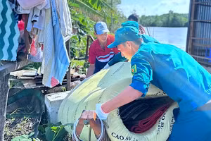 Lực lượng chức năng và đoàn thể xã Đất Mới (tỉnh Cà Mau) hỗ trợ giúp dân khắc phục hậu quả sau sạt lở đất.