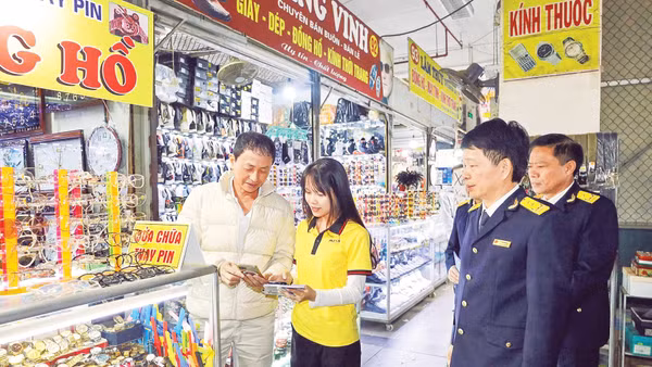 Cơ quan thuế cơ sở 16 Thành phố Hà Nội hướng dẫn hộ kinh doanh thực hiện thủ tục về thuế bằng phương thức điện tử. (Ảnh: HÀ ANH)