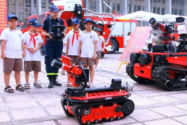 Chiến sĩ phòng cháy, chữa cháy và cứu nạn, cứu hộ biểu diễn sử dụng robot chữa cháy cho các em học sinh. (Ảnh: Công an Hà Nội)