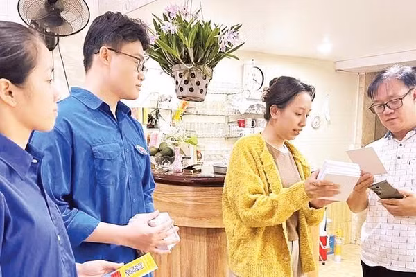 Thành viên tổ công nghệ số cộng đồng của phường Hồng Bàng hướng dẫn người dân sử dụng những tiện ích số (Ảnh HUY VŨ)