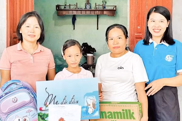 Cháu Hoàng Thị Linh Đan được chị Nguyễn Thị Ánh Tuyết (áo hồng) nhận làm con đỡ đầu từ khi vừa mất mẹ.