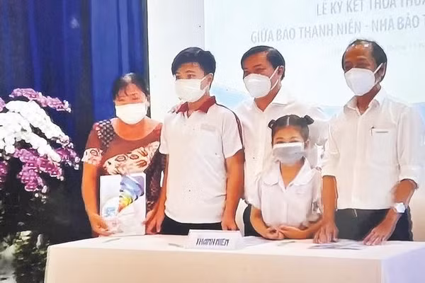 Đại diện Chương trình “Cùng con đi tiếp cuộc đời” trao suất bảo trợ cho em Lê Thị Ngọc Tuyết và em Lê Minh Khang có cha mất trong đại dịch Covid-19 (Ảnh BÁO THANH NIÊN)