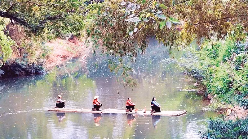 Khách du lịch trải nghiệm chèo bè mảng trên suối.