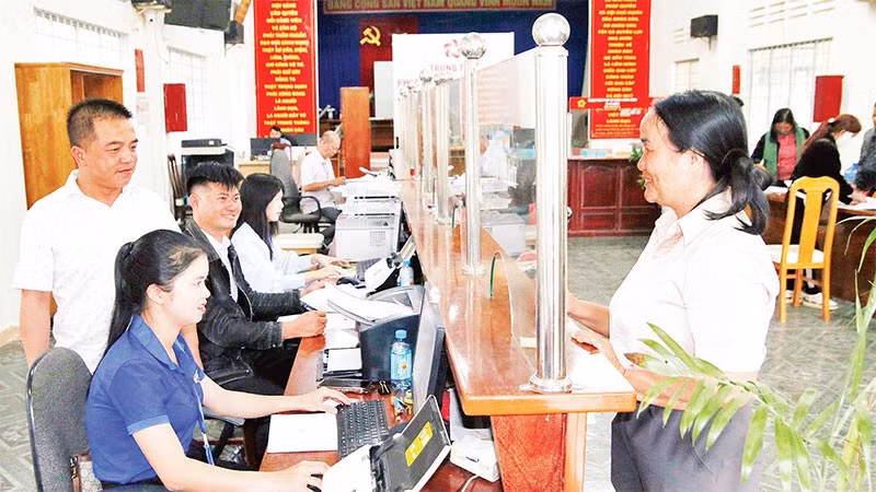 Chủ tịch Ủy ban nhân dân xã Tà Năng Nguyễn Vũ Linh Sang (bìa trái) hướng dẫn cán bộ Trung tâm phục vụ hành chính công xã ứng dụng AI phục vụ người dân làm thủ tục hành chính.