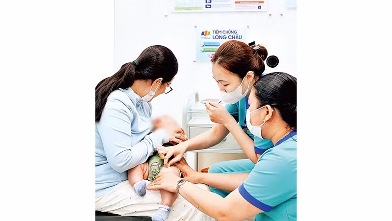 Các bậc cha mẹ tại Thành phố Hồ Chí Minh đưa trẻ đi tiêm vắc-xin phòng bệnh não mô cầu ở cơ sở tiêm chủng.