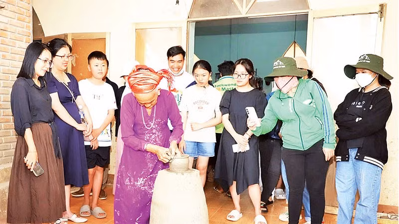 Du khách xem nghệ nhân làng nghề gốm Bàu Trúc, xã Ninh Phước, tỉnh Khánh Hòa biểu diễn nhào nặn sản phẩm.