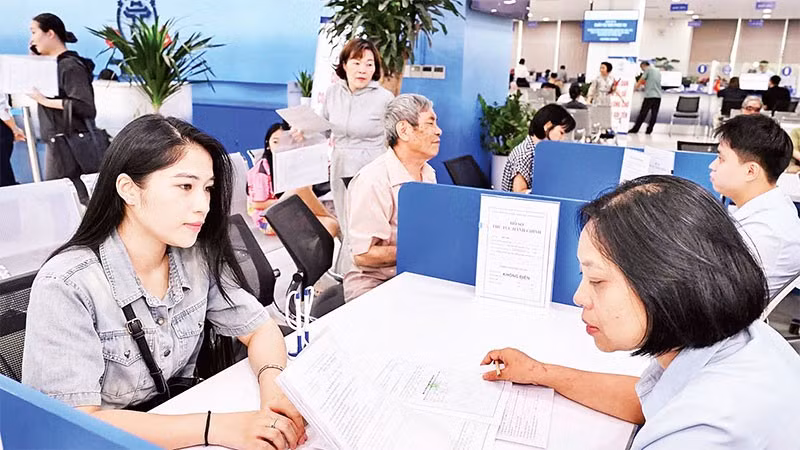 Cán bộ Trung tâm Phục vụ hành chính công Thành phố Hà Nội hỗ trợ doanh nghiệp, hộ kinh doanh làm thủ tục.