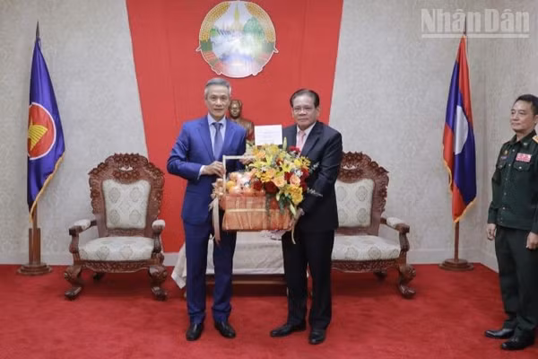 Đại sứ Nguyễn Minh Vũ (trái) chúc mừng Đại sứ Lào Buakeo Phumvongsay nhân kỷ niệm 50 năm Quốc khánh Lào. (Ảnh: Đại sứ quán Việt Nam tại Campuchia)