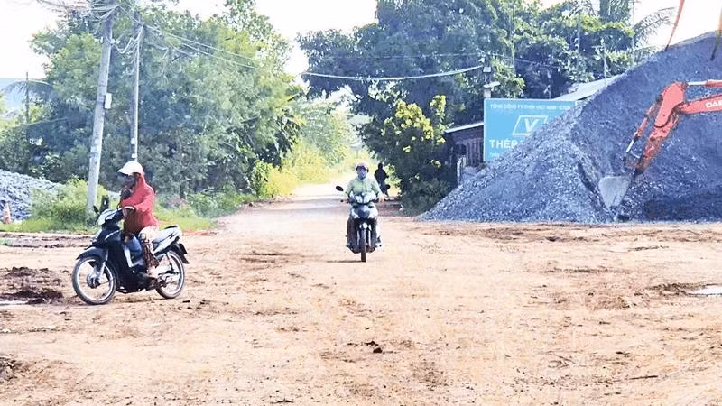 Mặt đường nhựa bị vật liệu rơi vãi biến thành con đường đất, nắng thì bụi, mưa thì sình lầy.