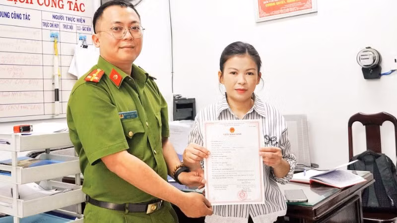 Thượng úy Nguyễn Quang Đạt trao giấy khai sinh cho chị Nguyễn Thị Trúc Mai.
