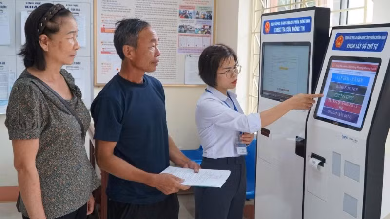 Cán bộ phường Mường Thanh hướng dẫn người dân thực hiện thủ tục hành chính trên cây ki-ốt tại trụ sở Ủy ban nhân dân phường.