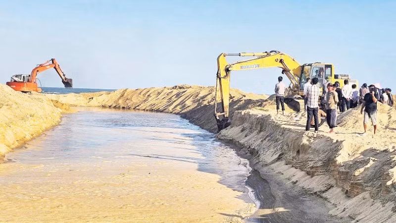 Xã Đông Trạch, tỉnh Quảng Trị huy động nhân lực, phương tiện đào cát lấp cửa sông Dinh lấy đường thủy cho ngư dân ra biển.