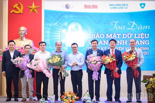 Đồng chí Lê Quốc Minh, Ủy viên Ban Chấp hành Trung ương Đảng, Tổng Biên tập Báo Nhân Dân, Phó trưởng Ban Tuyên giáo và Dân vận Trung ương, Chủ tịch Hội Nhà báo Việt Nam tặng hoa các diễn giả của buổi tọa đàm. Ảnh: THÀNH ĐẠT