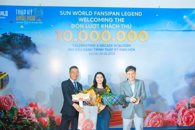 Ông Phạm Cao Vỹ - Chủ tịch Hiệp hội Du lịch tỉnh Lào Cai (bên trái) trao quà tặng cho vị khách thứ 10 triệu.