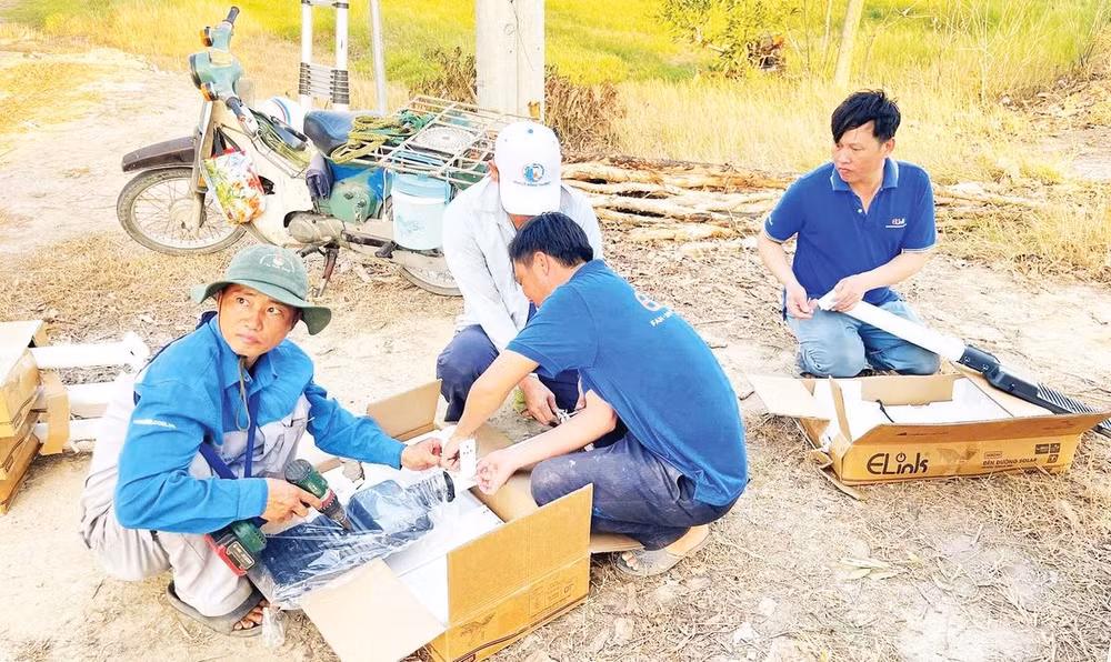 Công nhân lắp ráp đèn năng lượng mặt trời để thắp sáng đường tuần tra biên giới tỉnh Tây Ninh.