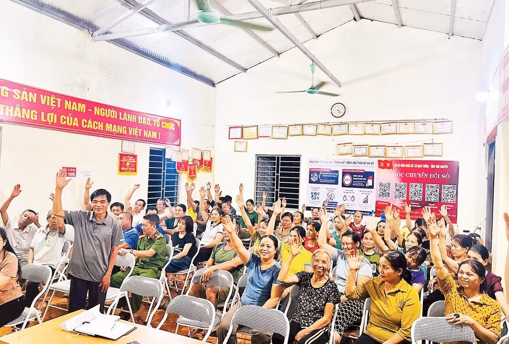 Đại diện các hộ gia đình thôn Đoàn Kết, xã Bạch Thông biểu quyết nhất trí phương án sắp xếp, tổ chức lại thôn, bản (Ảnh MINH NGUYỆT)