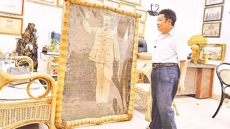 Nghệ nhân nhân dân Nguyễn Văn Trung bên bức chân dung Bác Hồ bằng mây tre vừa hoàn thiện.