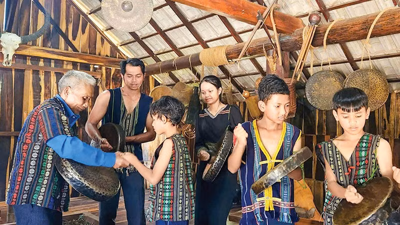 Già làng truyền dạy lớp trẻ đánh cồng chiêng tại làng du lịch Cơ Ho Cil, phường Cam Ly-Đà Lạt.